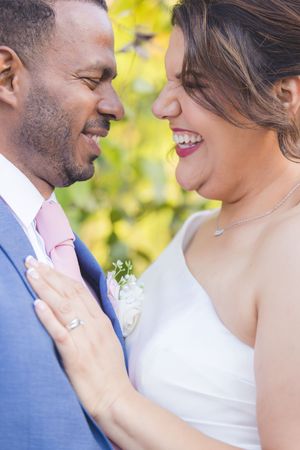 A romantic moment captured between a couple in wedding attire with soft yellow bokeh lighting in the background.