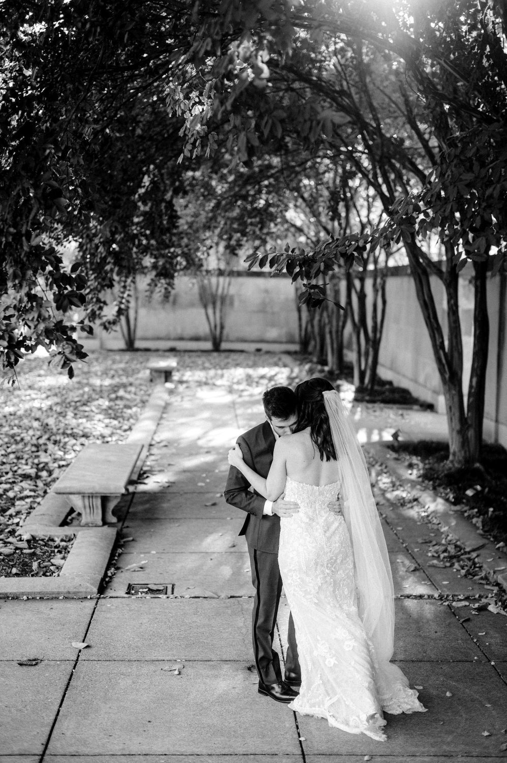 A black and white photo sequence showing a romantic dance between newlyweds on a tree-lined path.