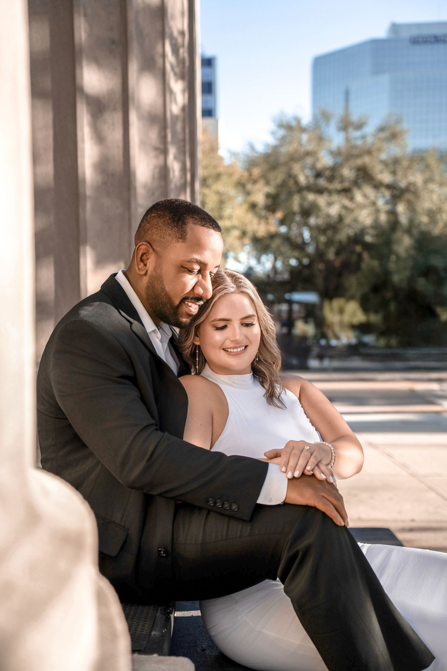 A couple shares intimate moments while sitting together on outdoor steps of a modern building in Downtown Tampa