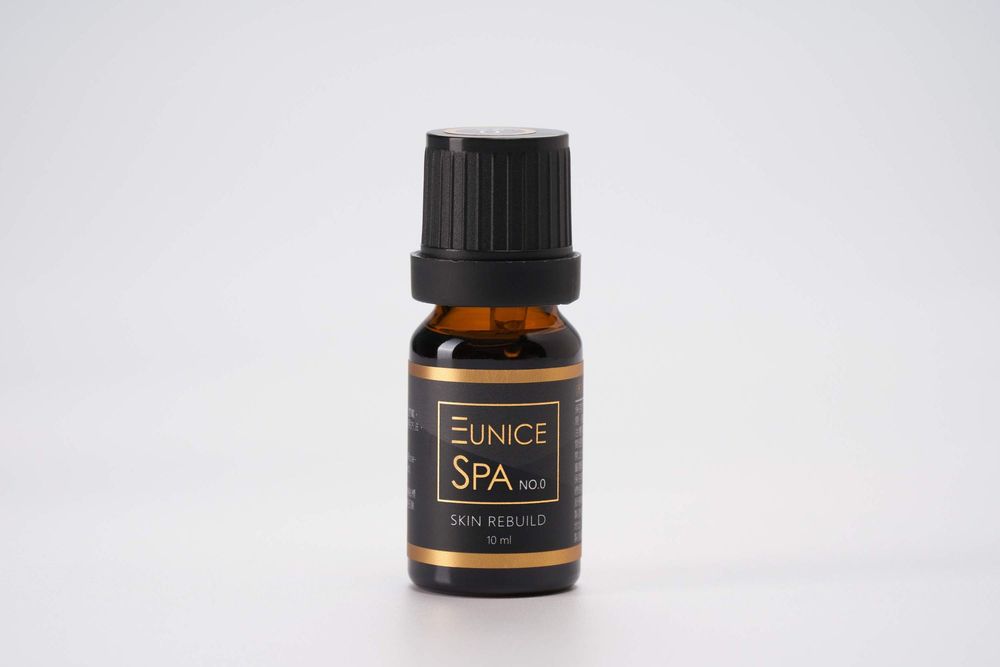 Small amber glass essential oil bottle with black dropper cap on white background.