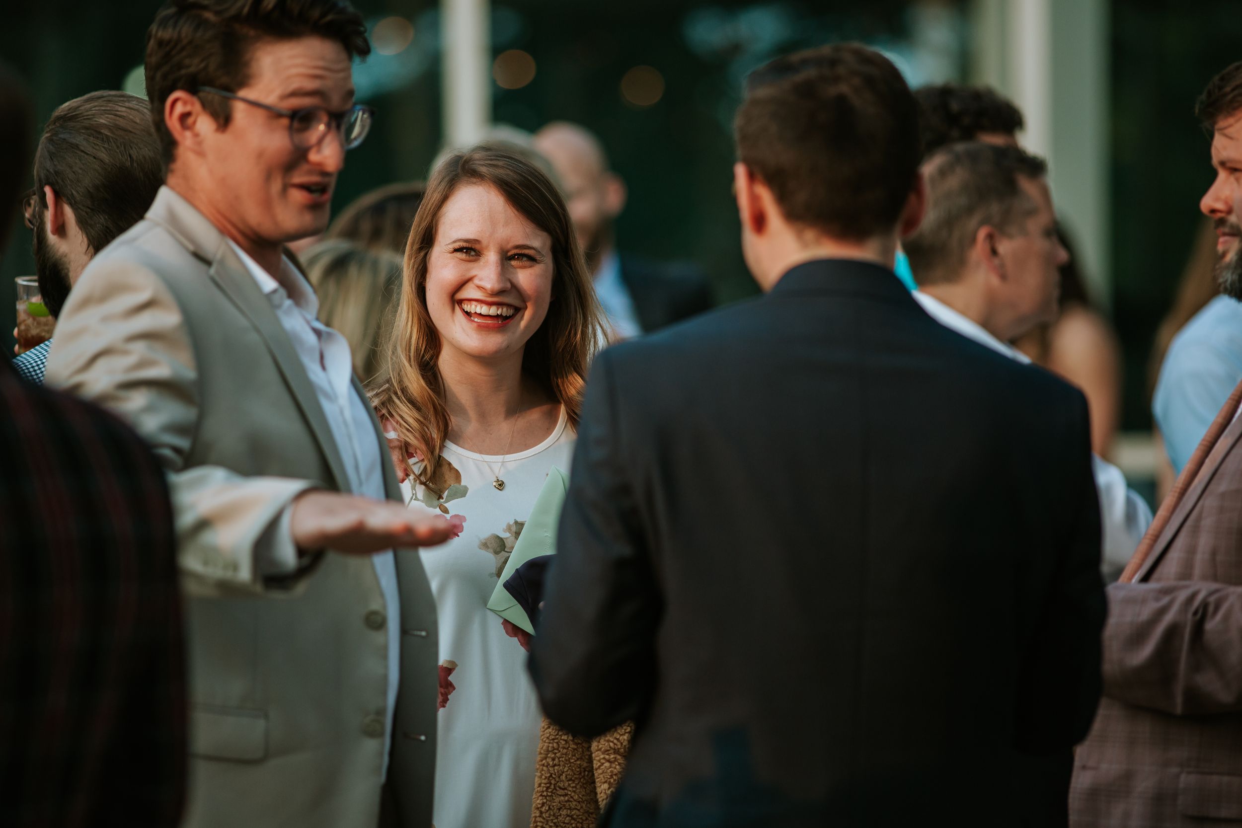 A group of people mingle and socialize at an indoor networking event or reception.