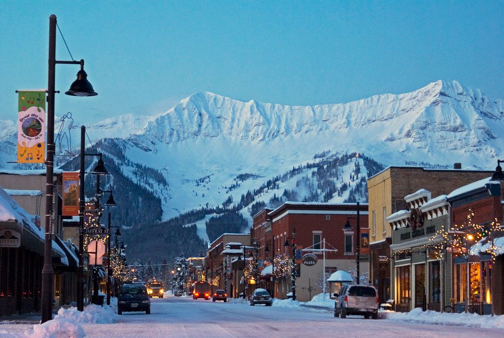 historic brick buildings in Fernie, BC at dusk with a snowy mountain in the background