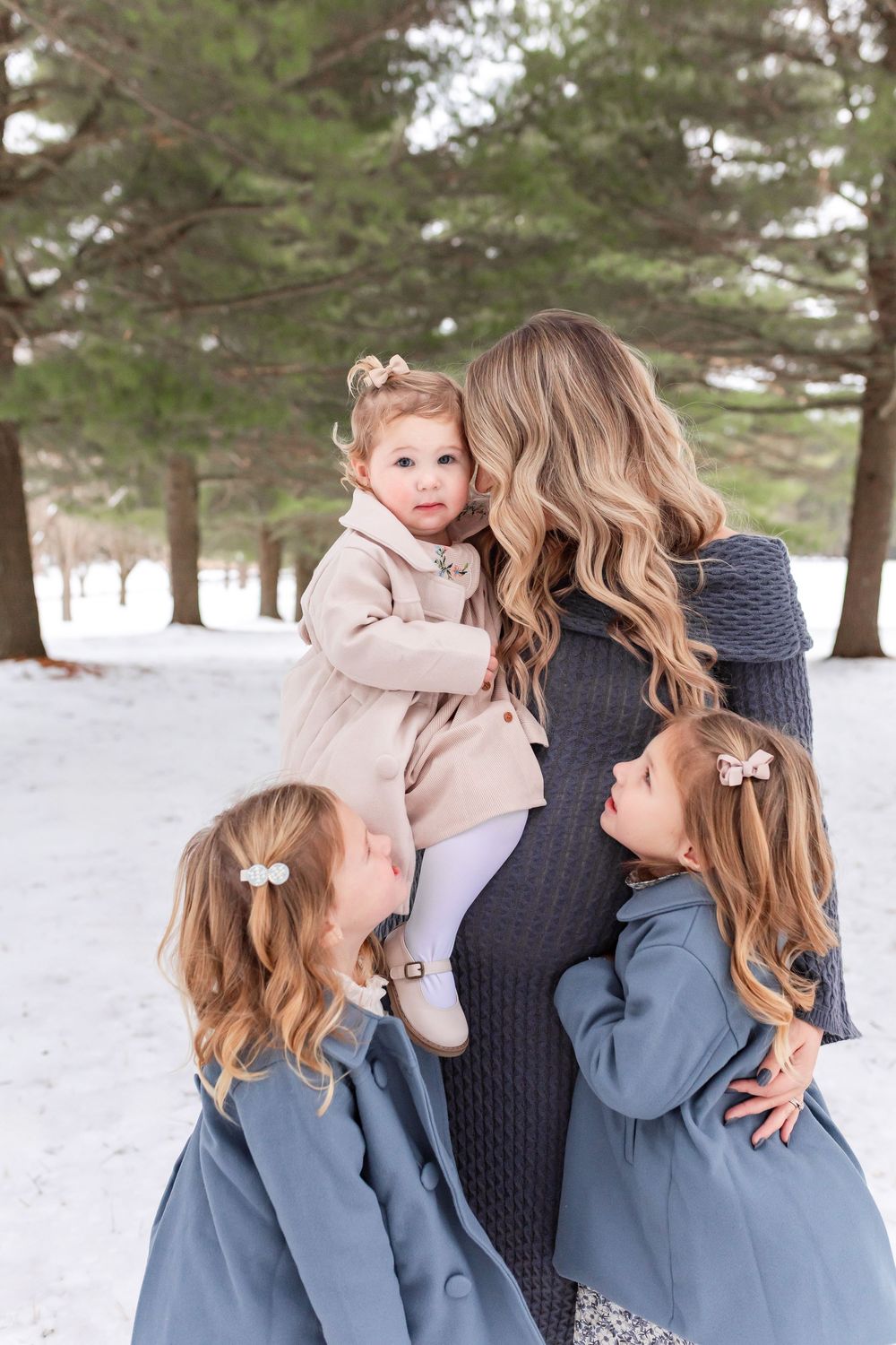 Three candid winter portraits show a tender family moment against a snowy evergreen forest backdrop.