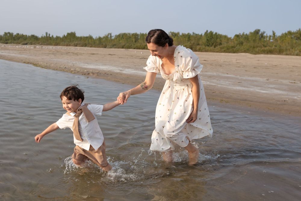 A mother and child play in the shallow waters of a lake.