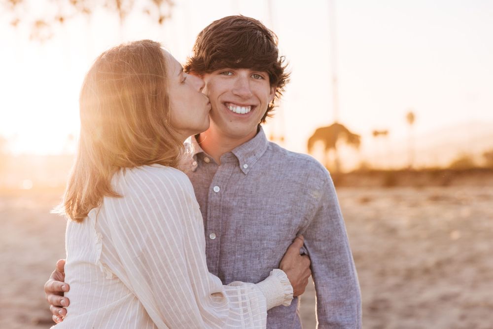Close up portrait of couple sharing intimate moment during beach sunset photoshoot.