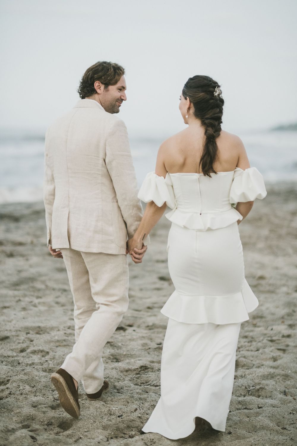 Newlyweds walk on a beach in Colombia.