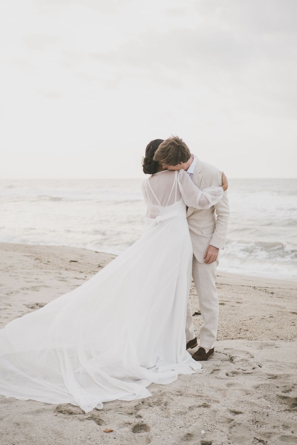Newlyweds hugging at a Colombian beach.