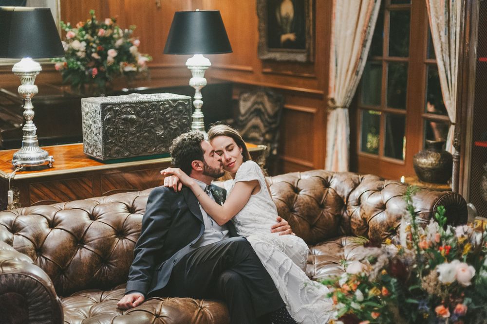 Newlyweds sharing a hug and kiss inside a house library.