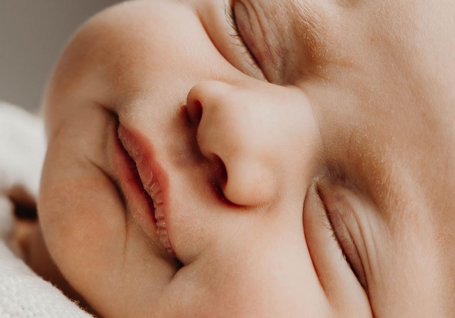 Close-up of a peaceful sleeping newborn baby's face showing delicate features.