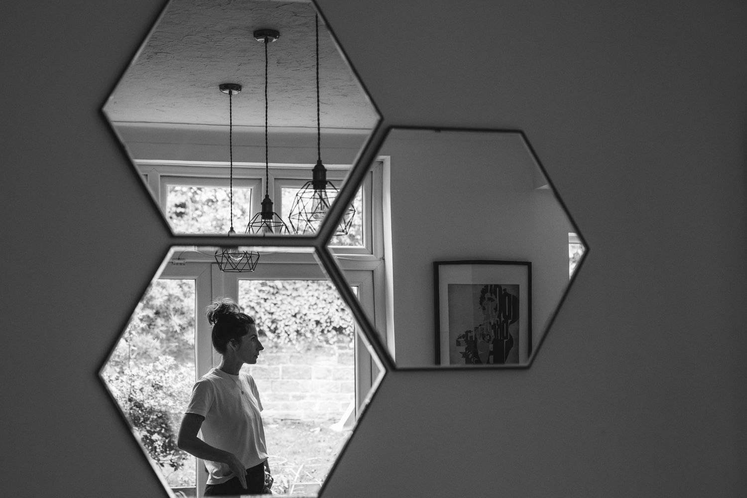 Hexagonal mirrors on a wall create geometric reflections of an interior space.