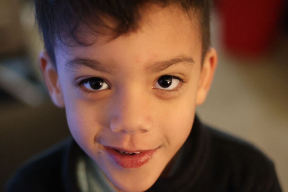 Portrait of a young child with a warm smile against a soft background.