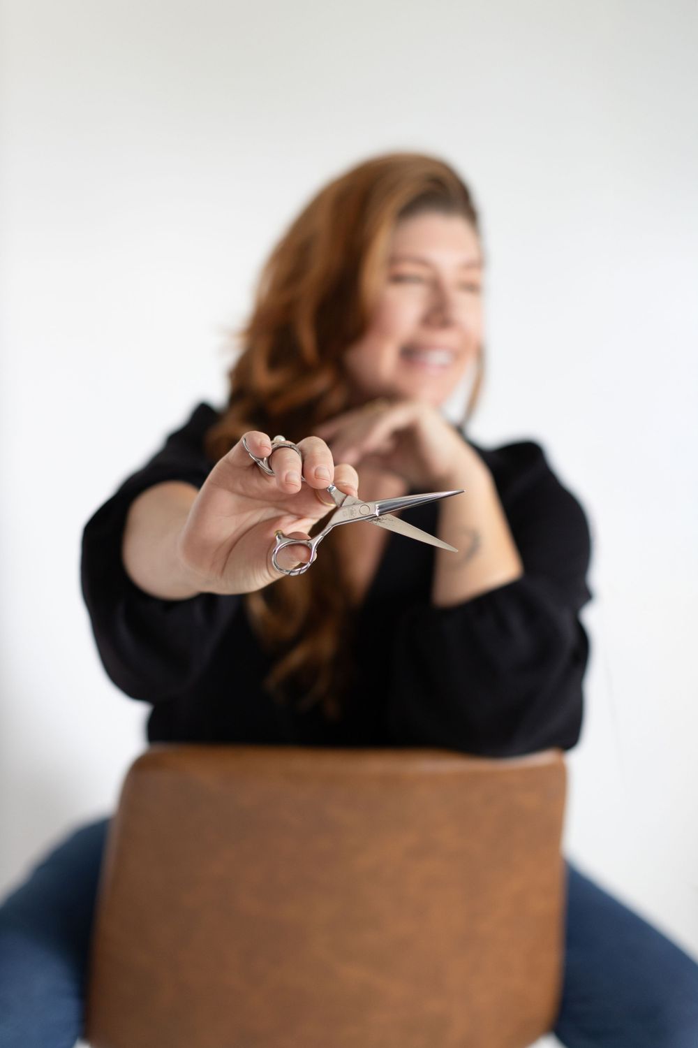 A candid studio shot showing scissors being held up in focus with a blurred background.