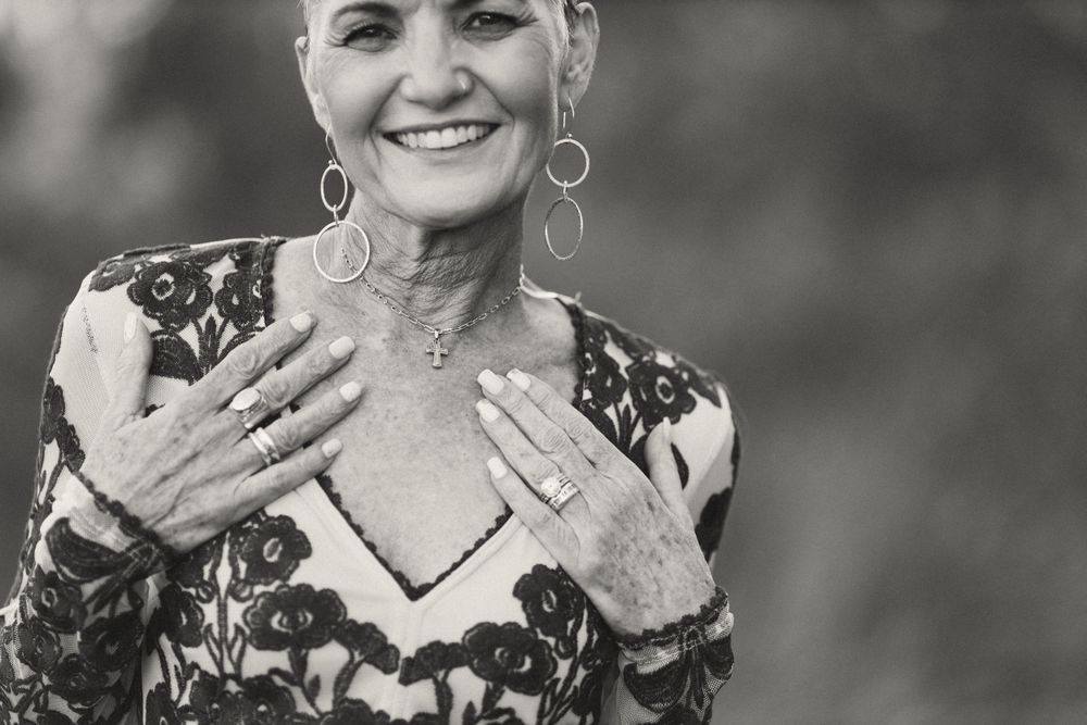 Black and white portrait showing joyful expression and statement earrings.