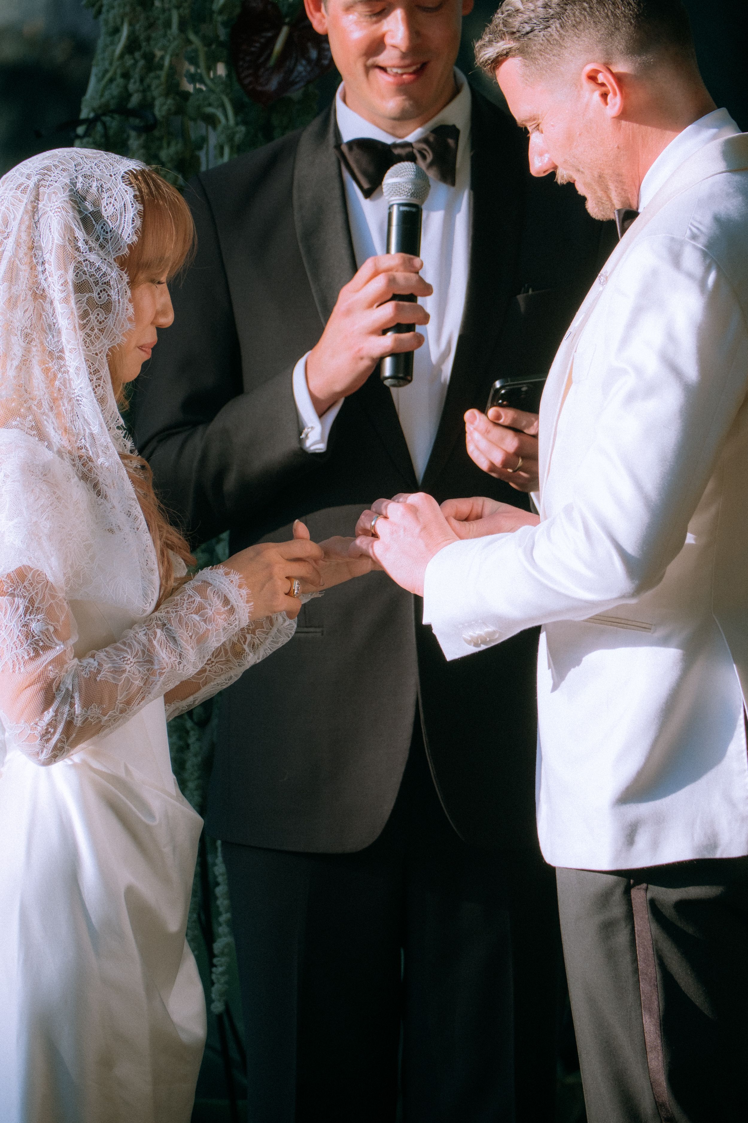 Intimate wedding ceremony moment during ring exchange with officiant.