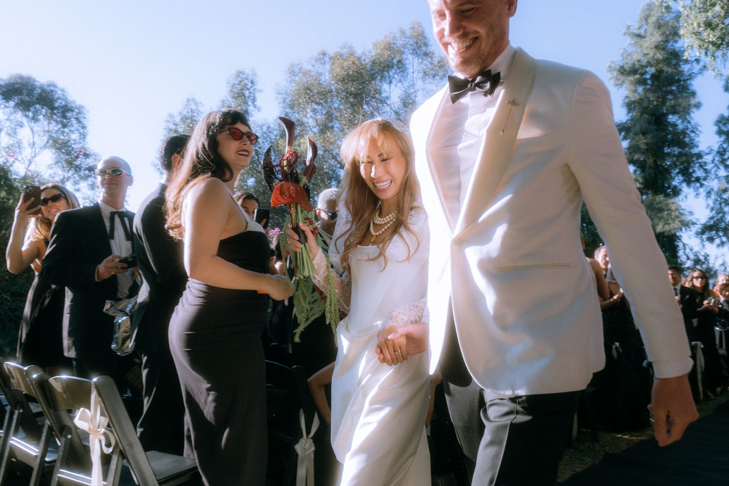 Wedding celebration with guests mingling outdoors on a sunny afternoon.