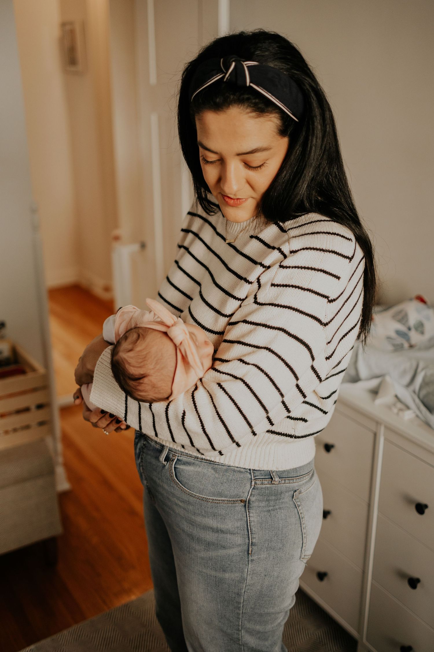 New mom comforting her newborn baby during lifestyle newborn photography session at home in Minneapolis