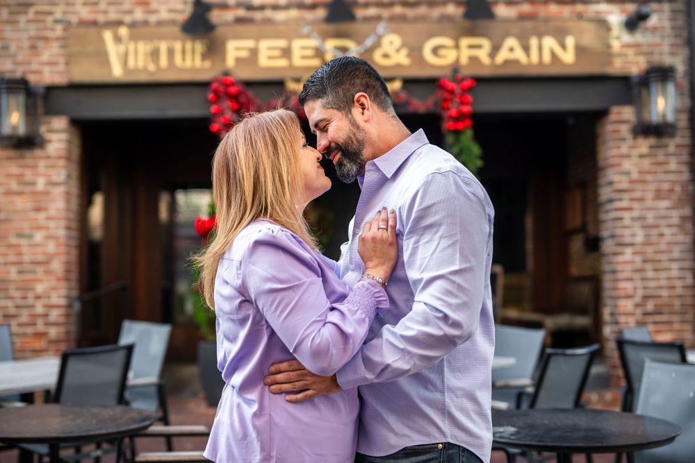 Romantic couple sharing an intimate moment outside a rustic brick building.