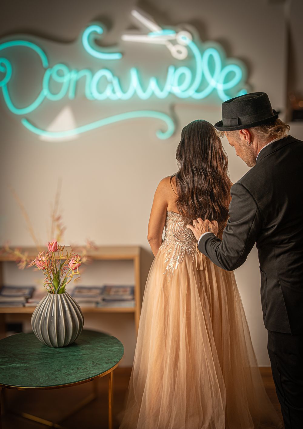Businessfotografie, Business Projects. Elegant scene under turquoise neon sign with floral decor and evening wear.