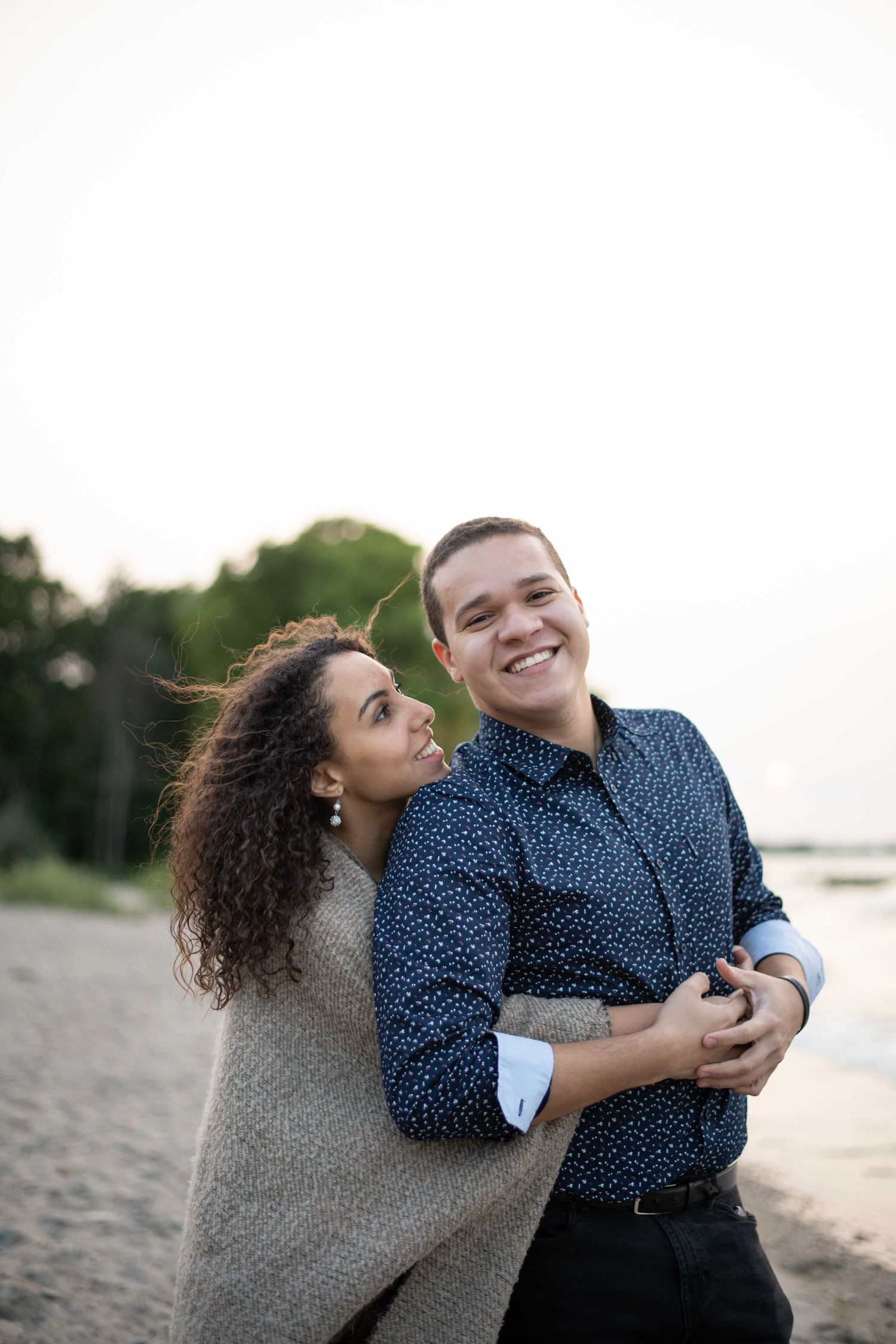 A candid beachside moment showing laughter and joy at sunset.