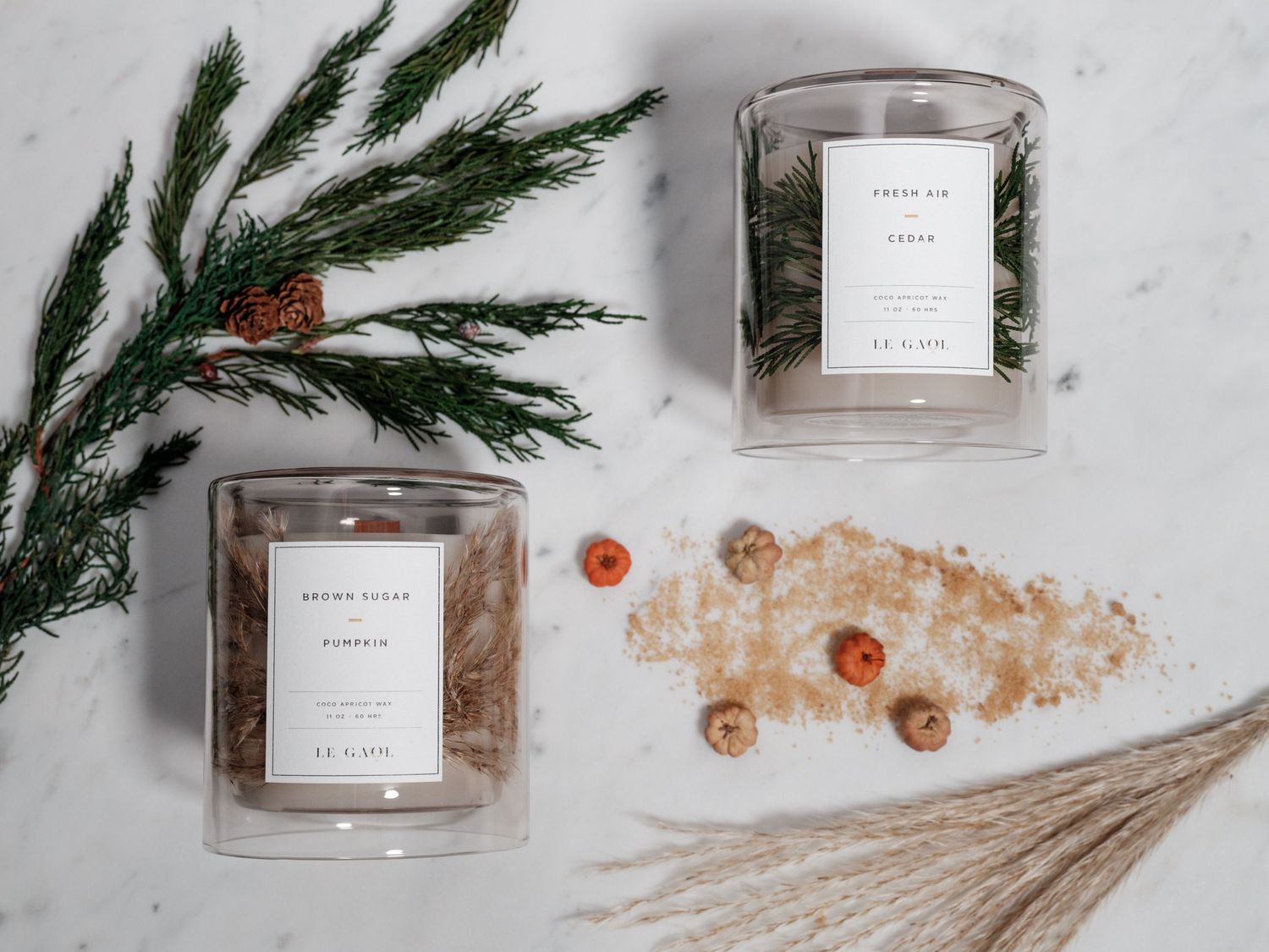 Aesthetic product flatlay with candles, pine branches and crystalline decorative elements.