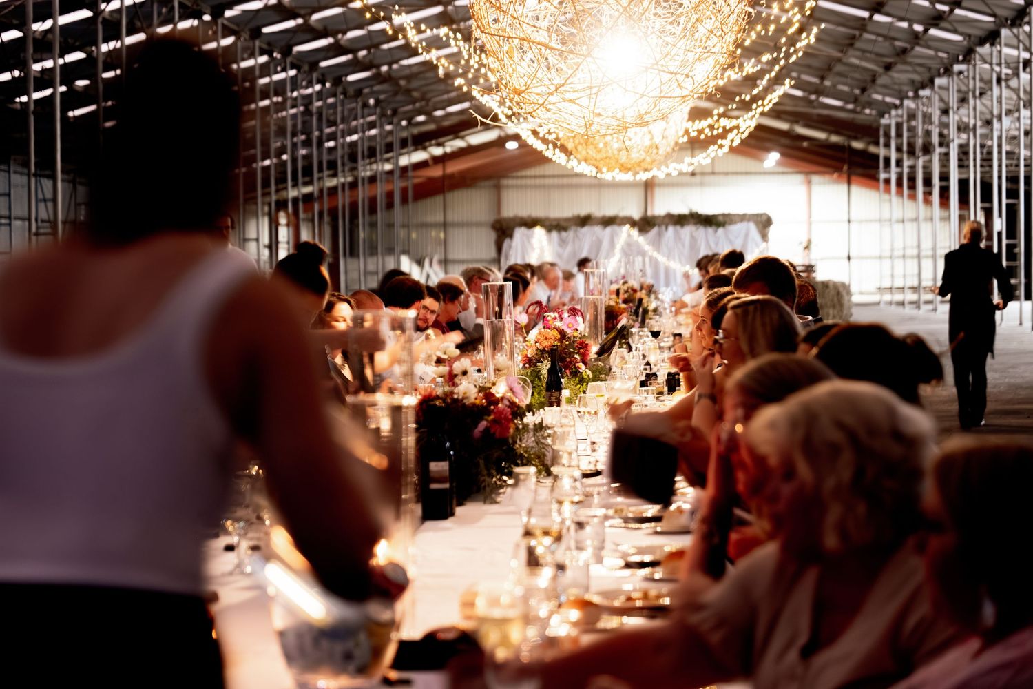 Elegant dining room with crystal chandeliers and long tables set for a formal event.