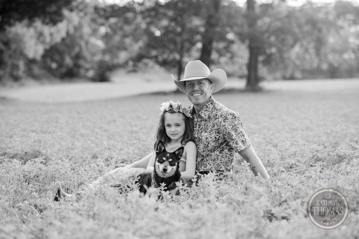 Black and white portrait in a sunny meadow showcasing rustic western style and casual charm.