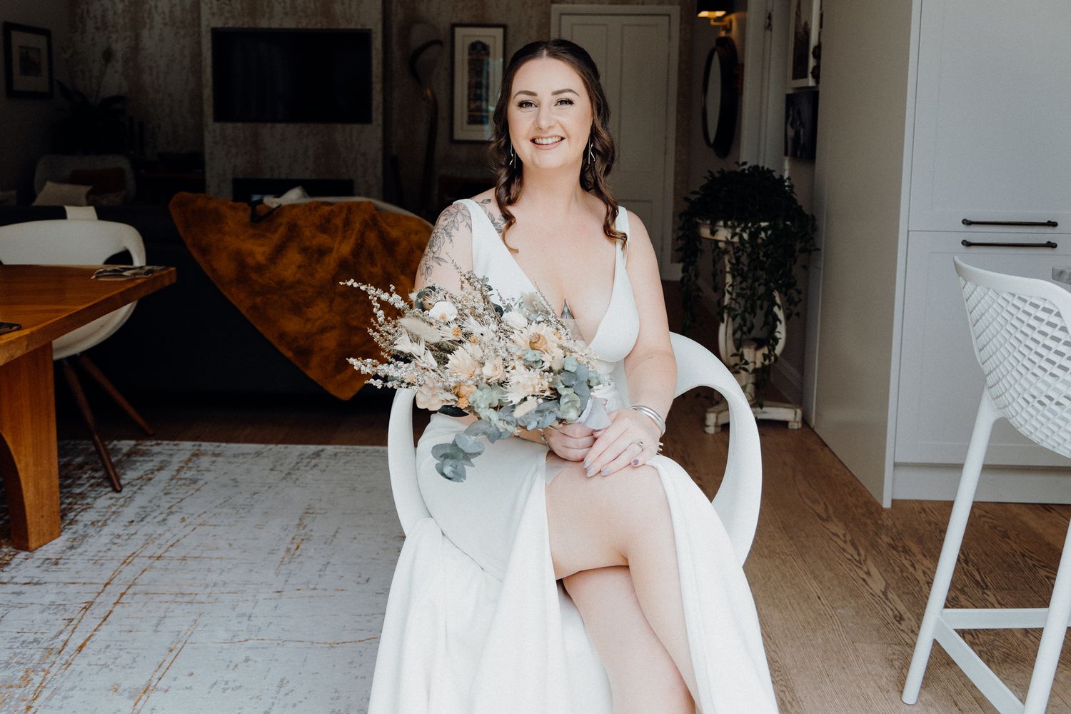 A bride in a white gown holding a neutral-toned dried floral bouquet, captured by Apertured Media Auckland Wedding Photographer.