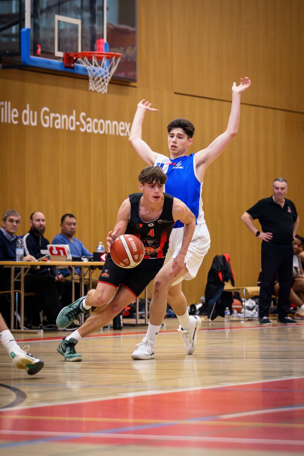 Intense basketball action showing players competing in a Grand-Saconnex indoor game.