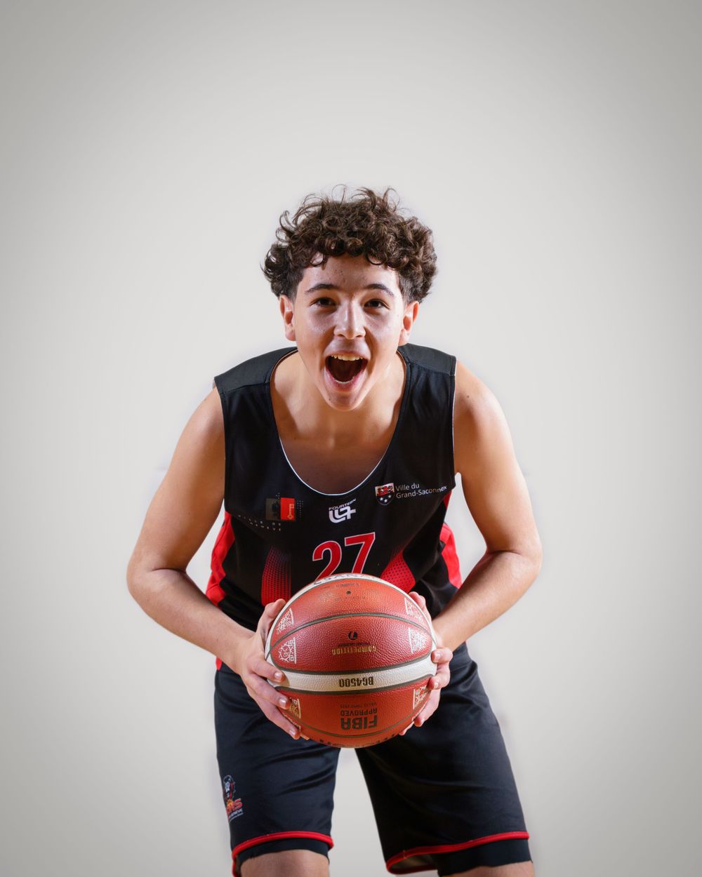 Basketball player in black jersey number 27 shows excitement while holding ball.