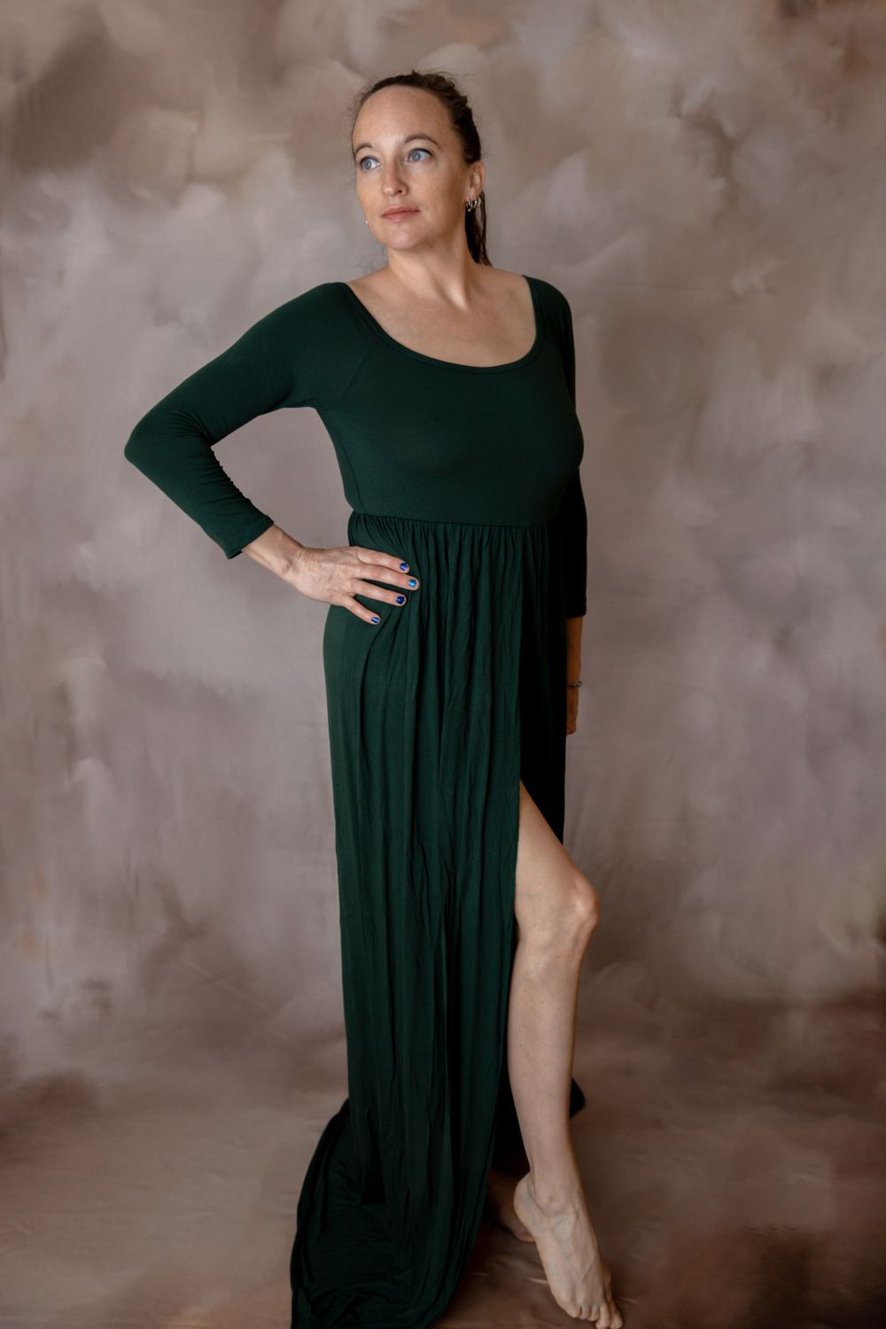 Pregnant woman in dark green gown during maternity photography session in Central Florida.