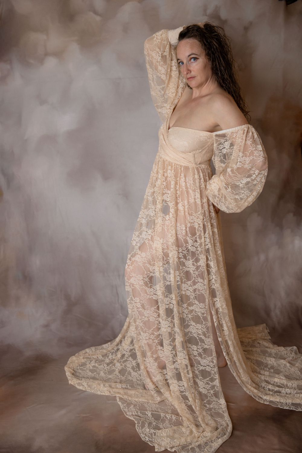 Pregnant woman in ivory lace gown during Central Florida maternity photography session.