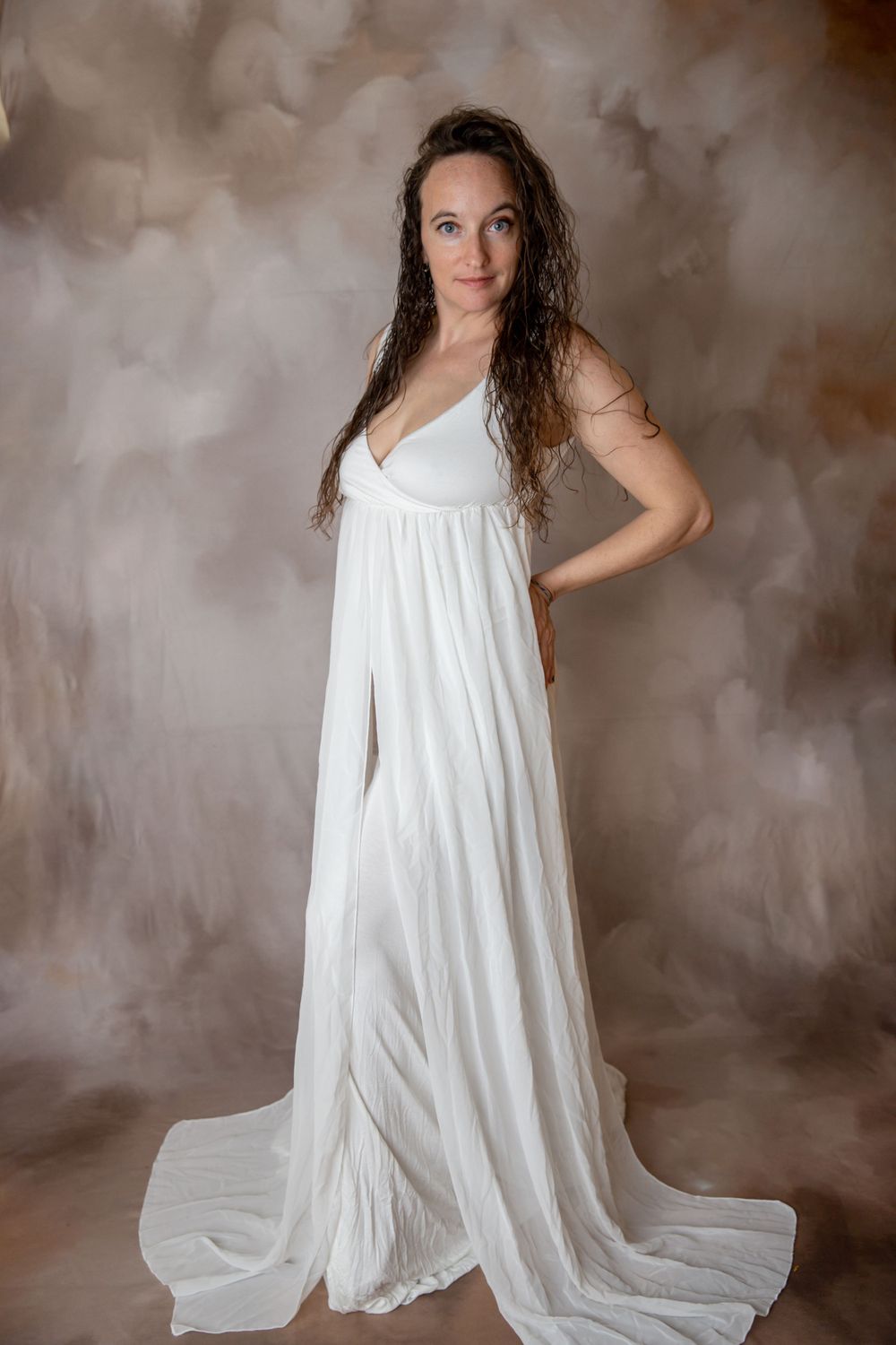Pregnant woman in white chiffon gown during Central Florida maternity photography session.