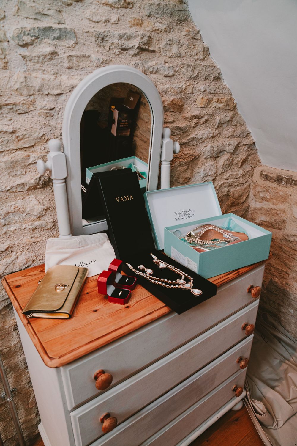 Vintage dresser with mirror displaying wedding accessories and jewelry.
