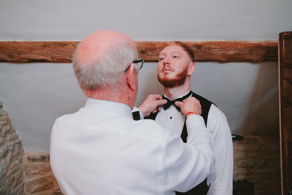 Final adjustments being made to groom's bow tie before the ceremony.