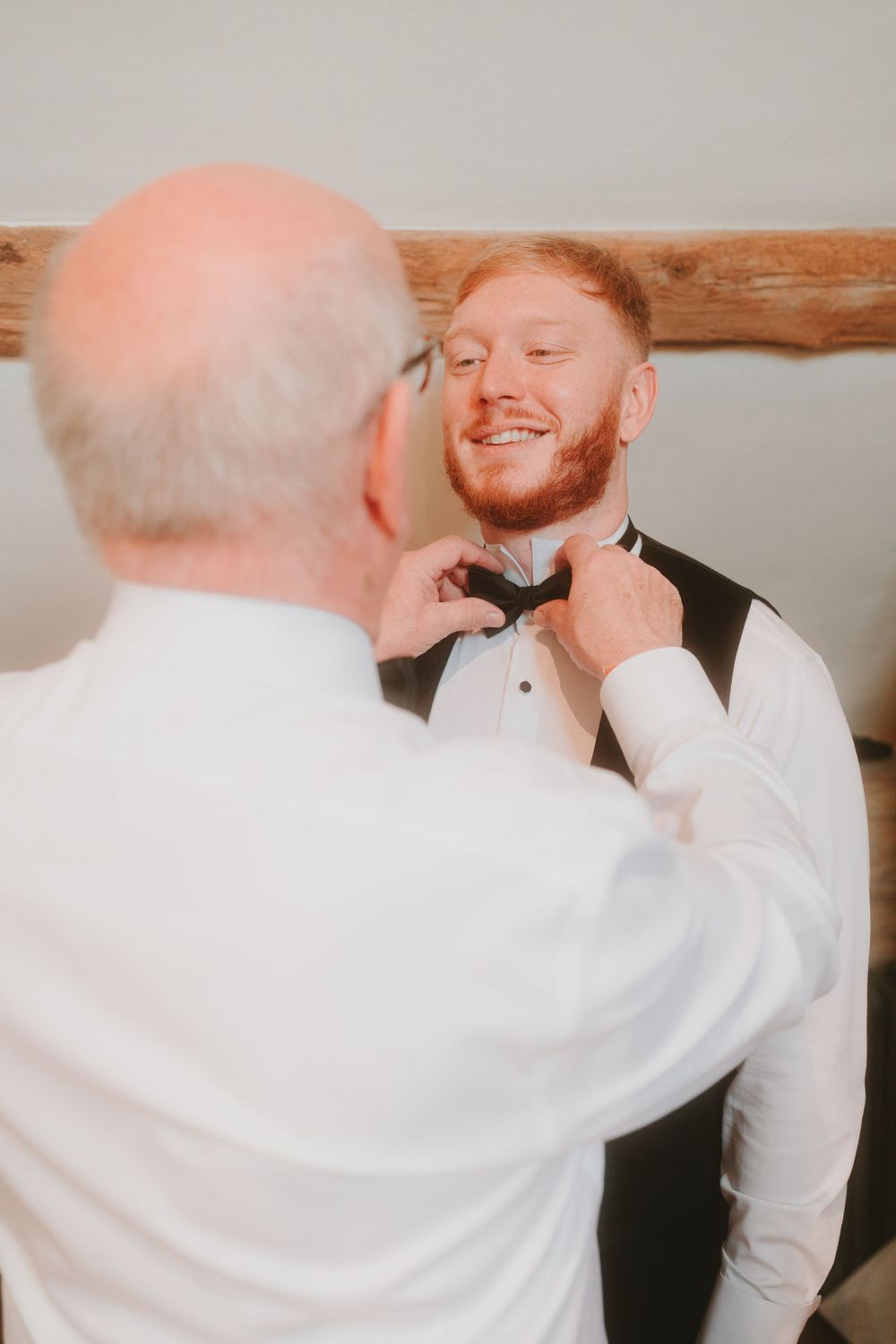 Final touches being made to formal wedding attire indoors.