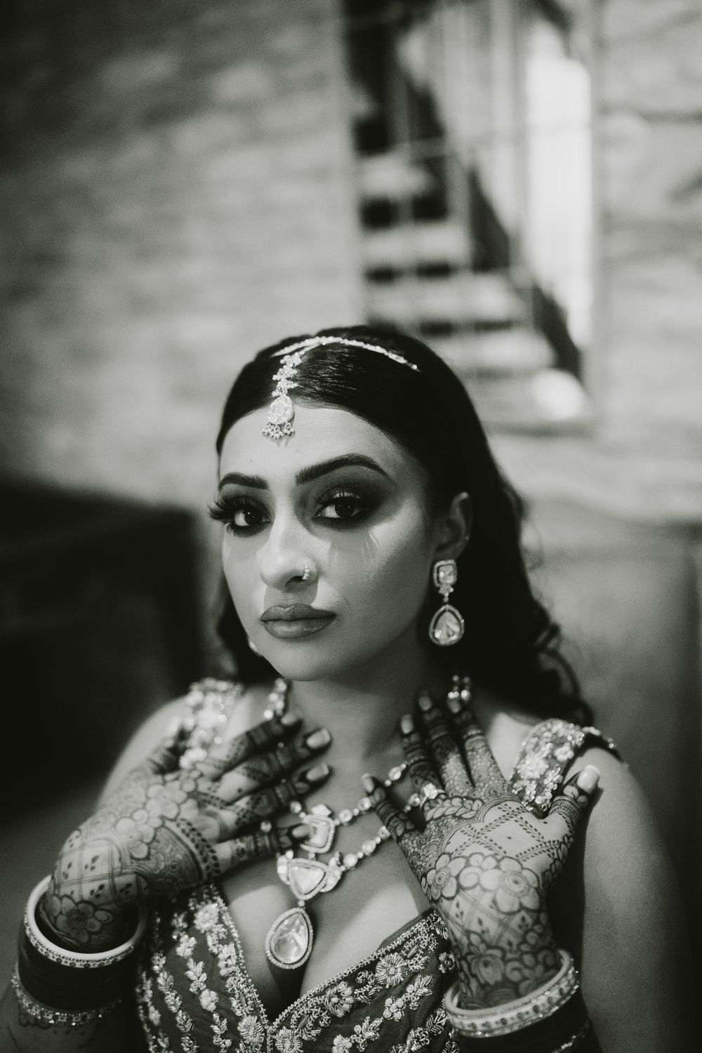 Dramatic black and white portrait showcasing traditional Indian bridal jewelry and makeup.
