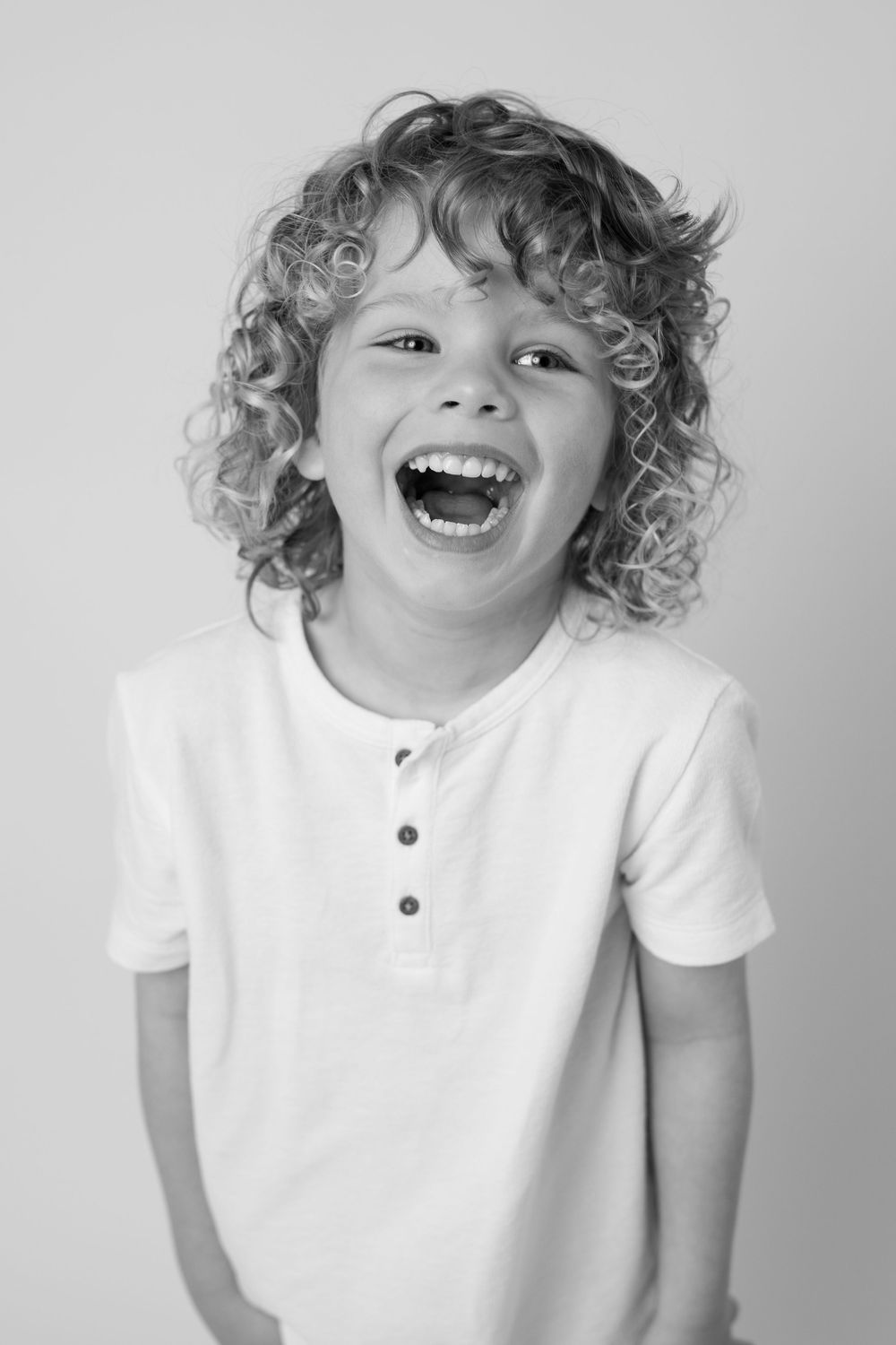 Sequence shows joyful expressions and curly hair wearing a white shirt against a light background.