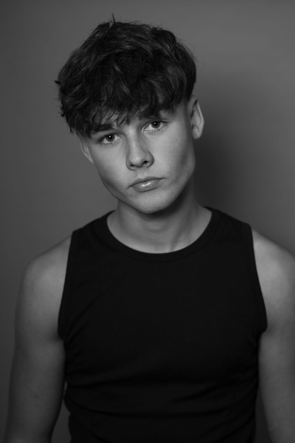 Black and white portrait series showing four different poses in a sleeveless black top against a simple background.