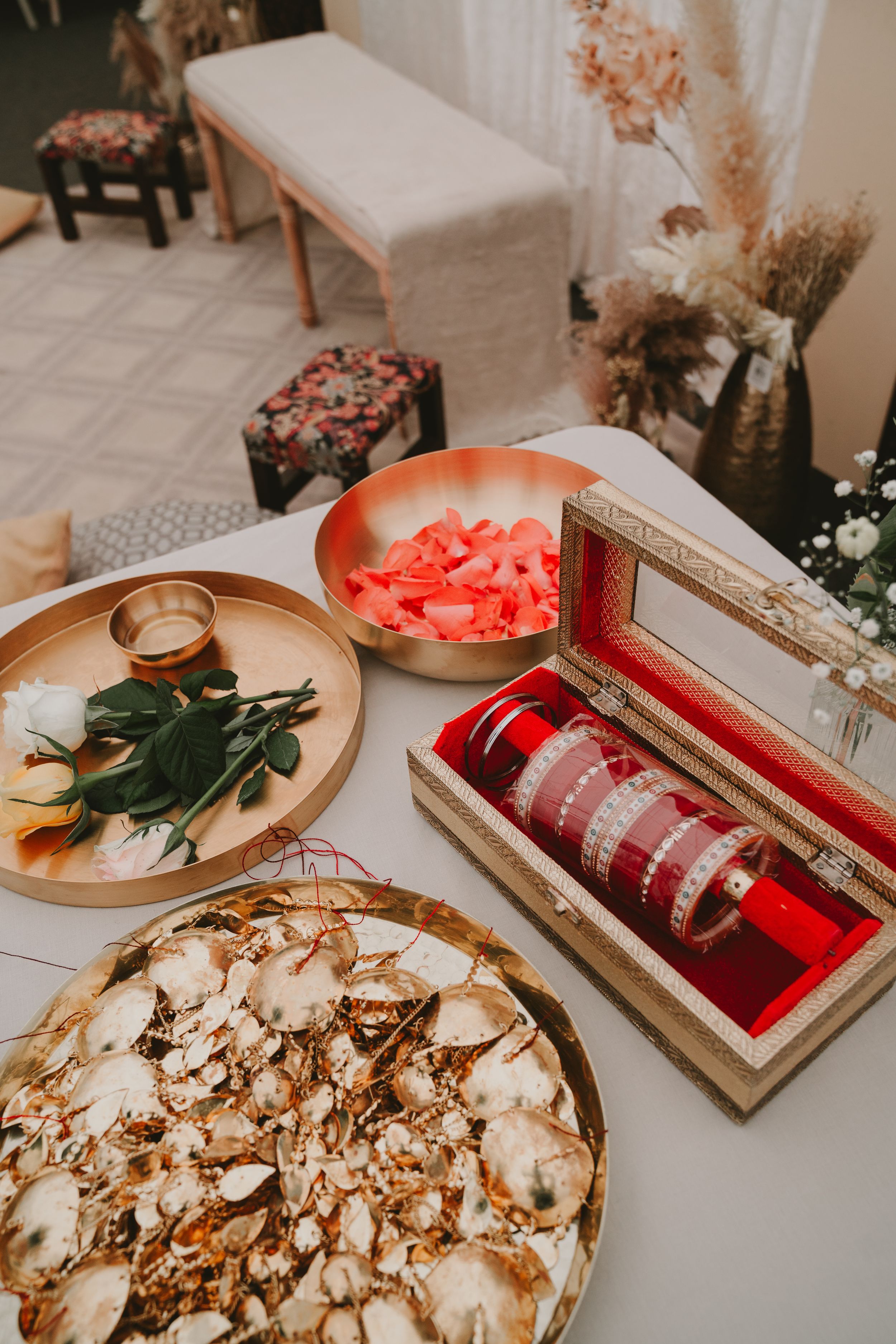 Wedding decorations with traditional red bangles, dried flowers and dessert display.