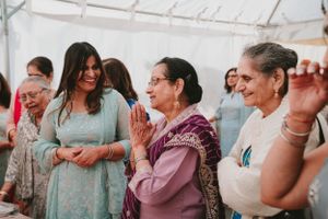 Guests dance and celebrate at a joyous cultural event wearing traditional clothing.