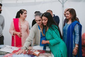 Wedding guests gather around a table examining traditional items and decorations.