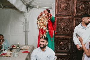 Traditional Indian wedding scene showing festive decorations and celebratory moments in a decorated tent space.