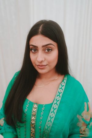 Portrait featuring emerald green traditional Indian dress with gold embellishments.