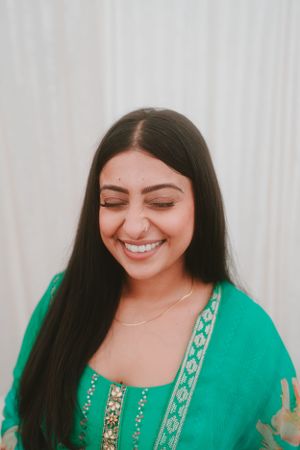 Portrait showcasing joyful expression with traditional Indian attire and jewelry.