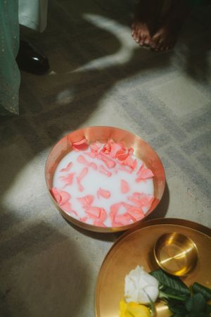 Pink decorative elements arranged in a copper plate with flowers on the side.