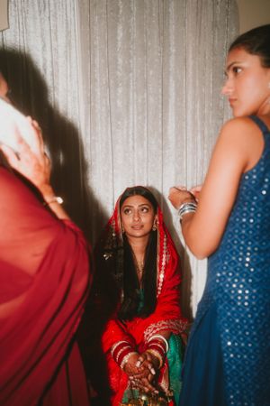 Traditional South Asian wedding ceremony preparation with attendants in colorful attire.