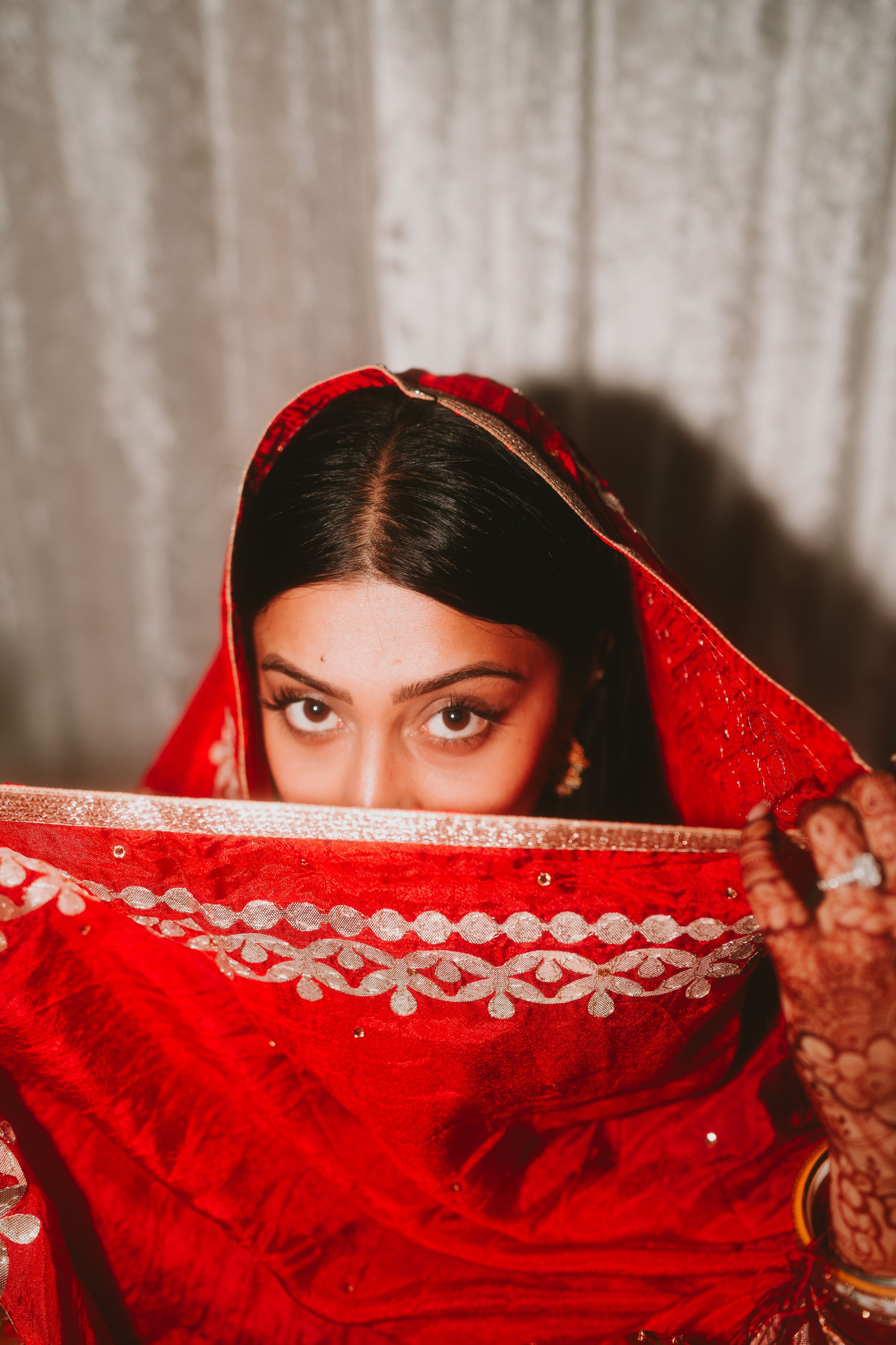 Traditional red bridal dupatta with gold trim frames against white background.