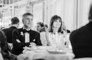 Elegant black and white photo of wedding guests dining at a formal reception.