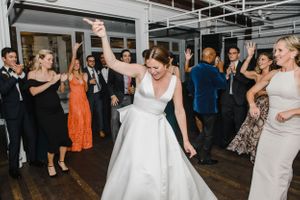 Wedding celebration on a dance floor with guests in formal attire dancing and celebrating.