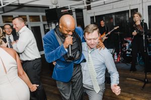 People dancing and celebrating at an indoor party with live band performing.